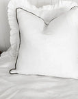 Linen cushion with piped edge in white