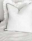 Linen cushion with piped edge in white